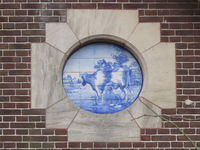 902881 Afbeelding van een rond Delfts blauw tegelplateau met een afbeelding van het melken van een koe, in een ...